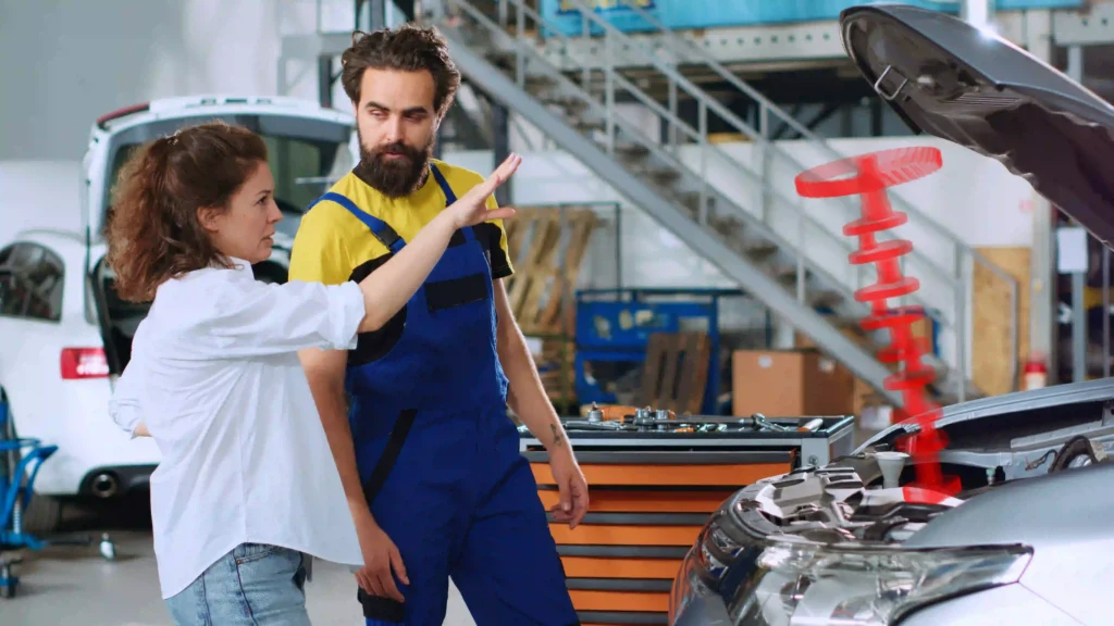 Un técnico automotriz explicando los puntos de inspección de una mantención preventiva según la pauta del fabricante.